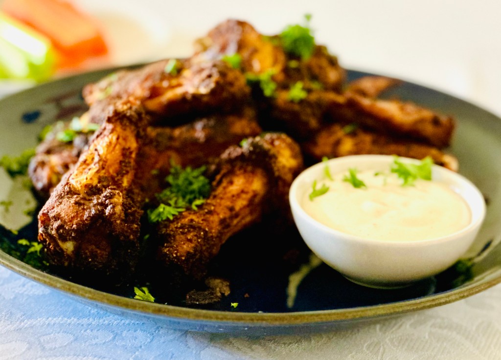 Plate of homemade crispy baked chicken wings and dipping sauce