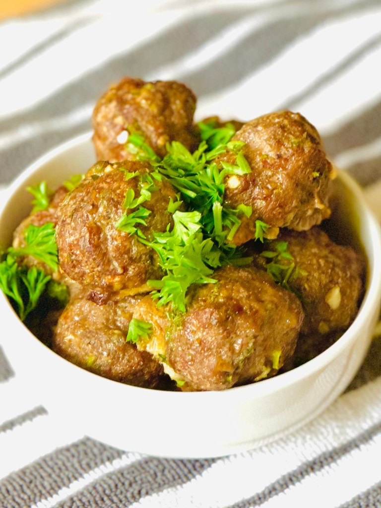 Photo of homemade Italian beef meatballs served with a garnish of fresh parsley