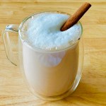 A clear mug of homemade cinnamon tea with hot milk