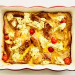 Tray of everything bagel baked with eggs, cheese, and grape tomatoes