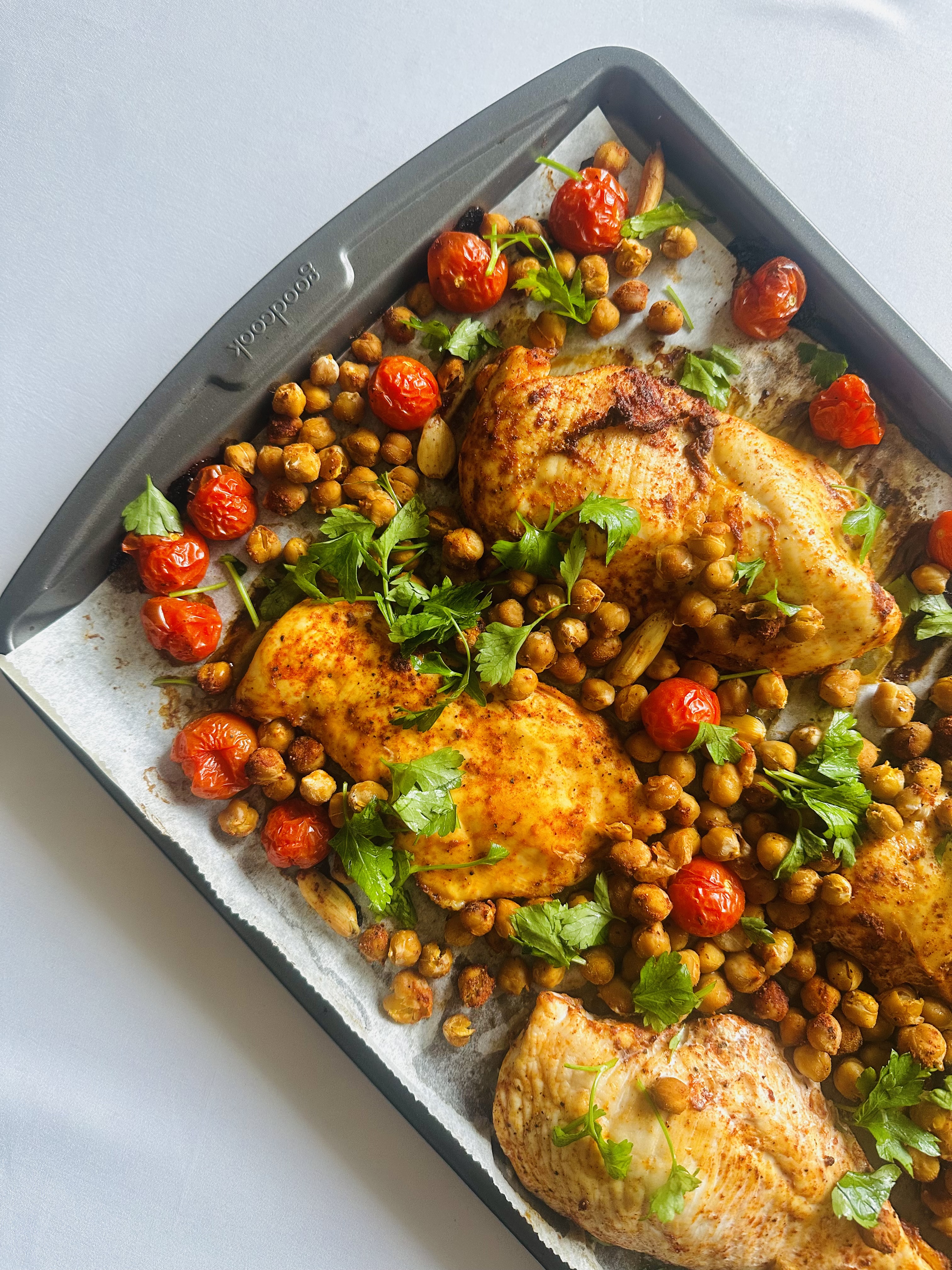 Sheet pan full of cherry tomatoes, chicken, and chickpeas