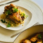 Plate full of rice topped with turmeric-spiced chicken