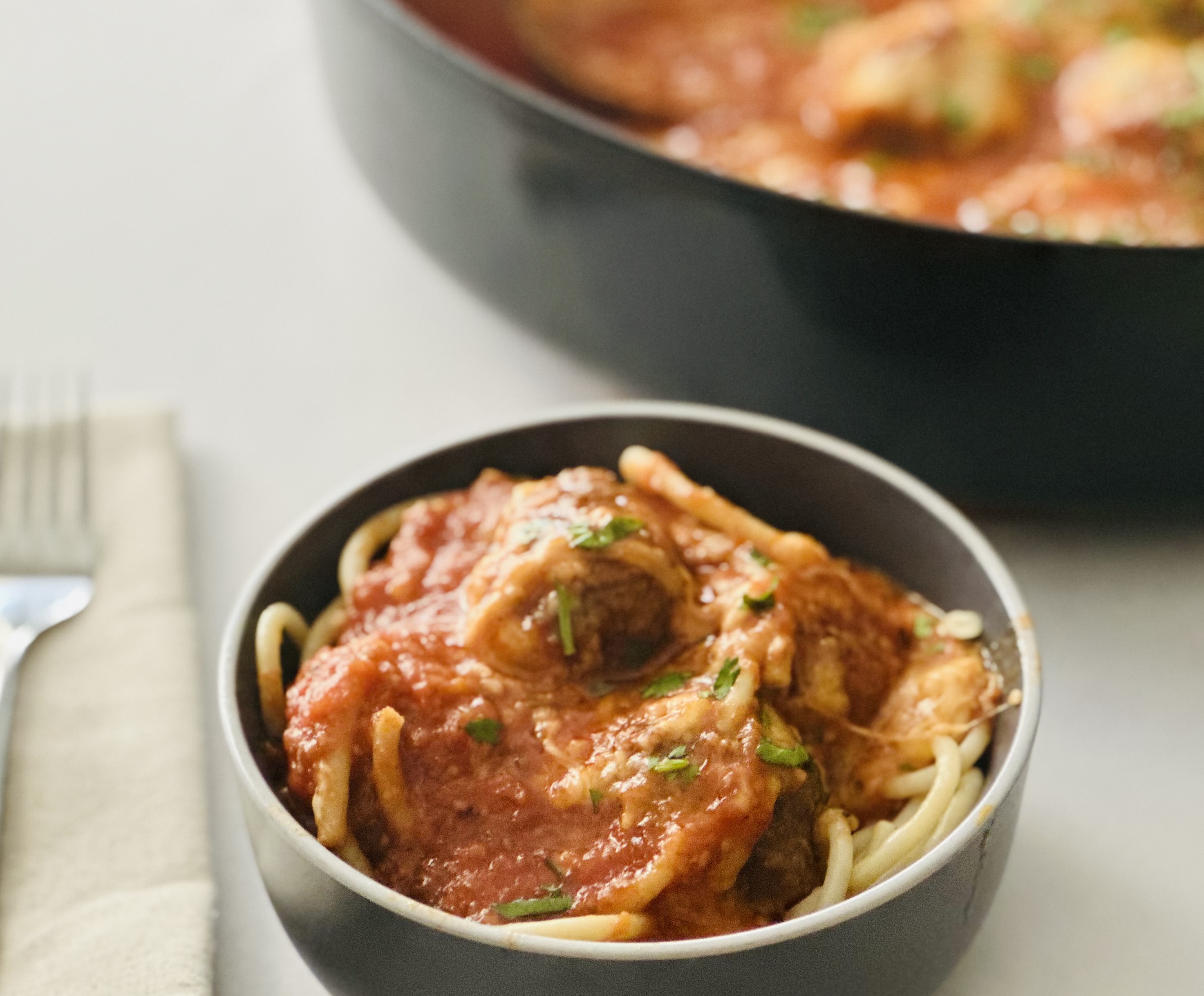 Bowl of spaghetti topped with marinara and beef meatballs