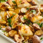 Roasted cod & potatoes on a sheet pan with shallots and garnished with parsley