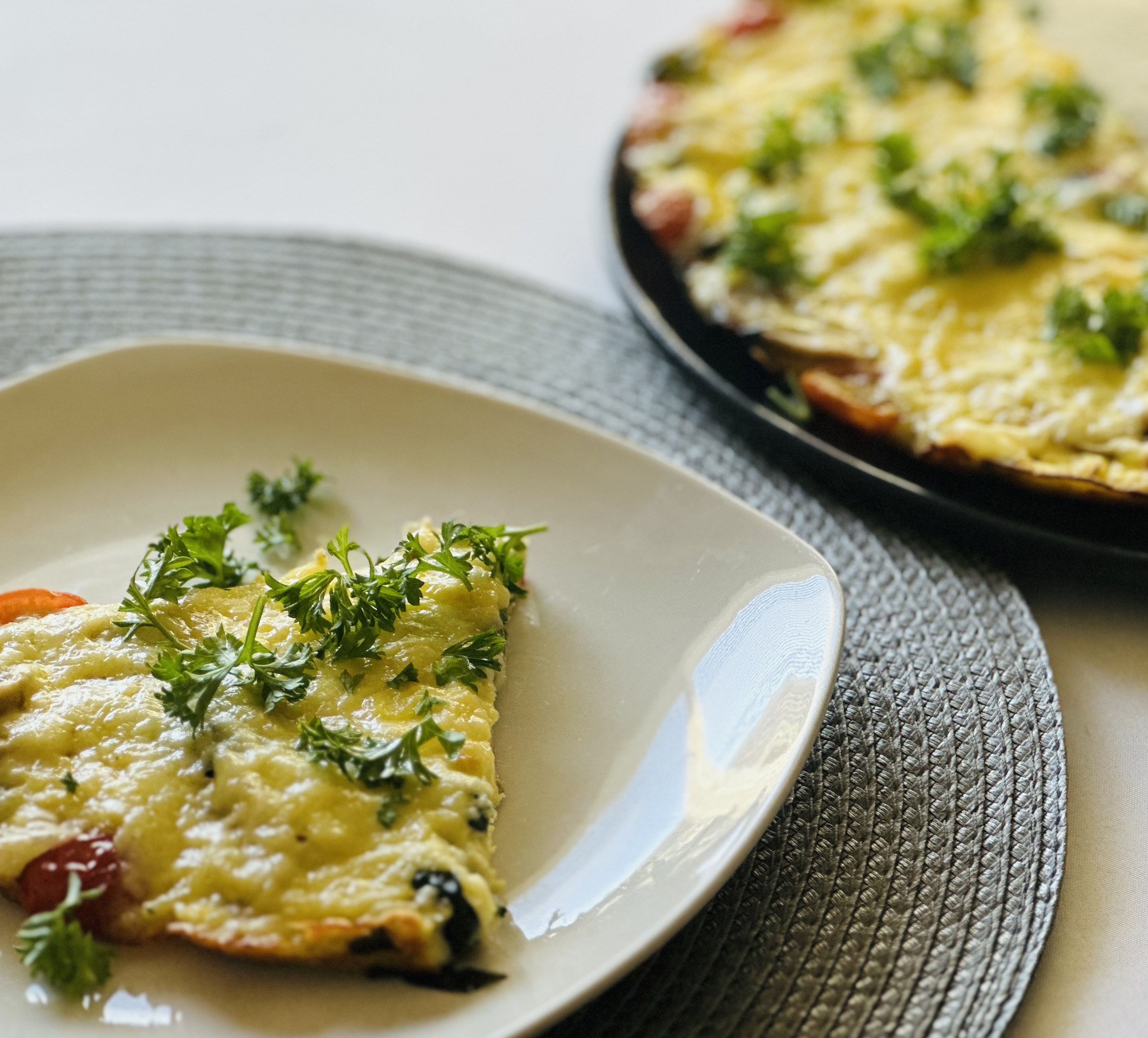 A plate of egg frittata on a placemat