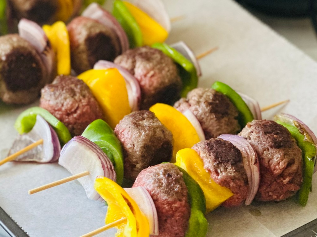 Wooden skewers with meatballs and grilled veggies threaded