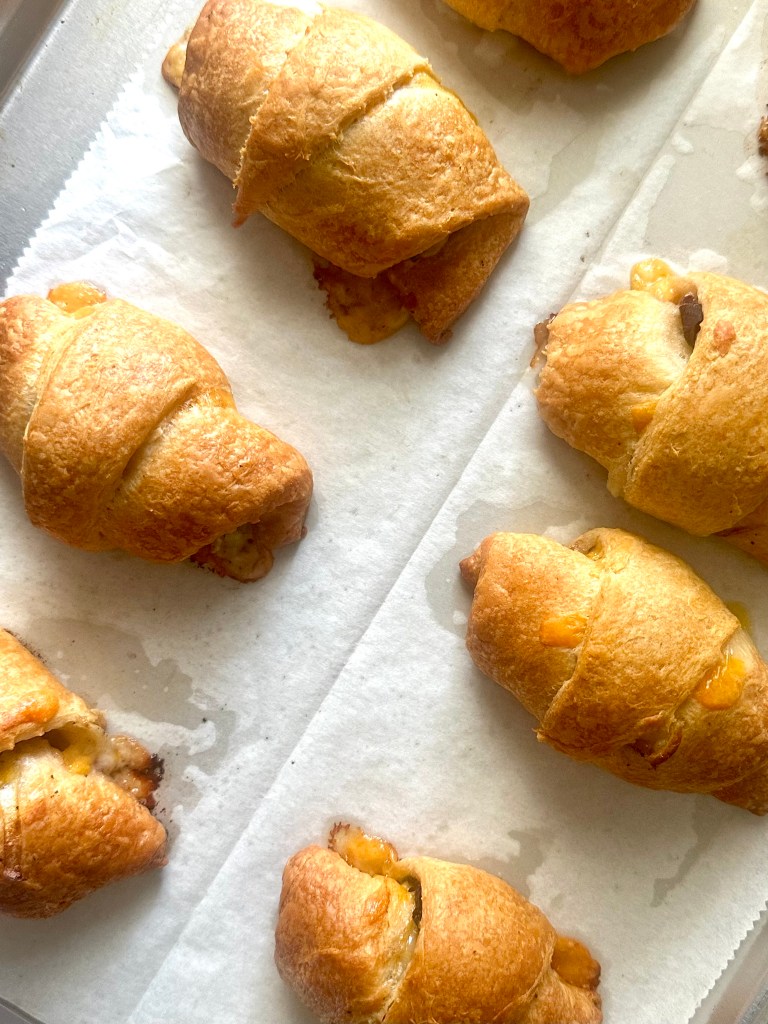 Tray of baked crescent rolls filled with Philly cheesesteak fillings
