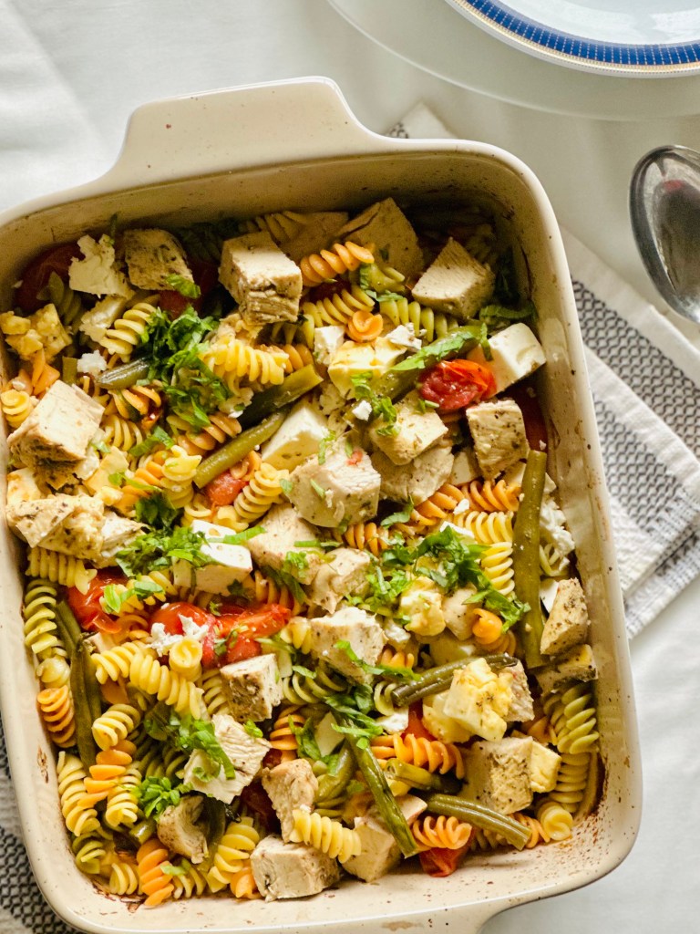 Baking dish with baked chicken, roasted veggies, and rotini