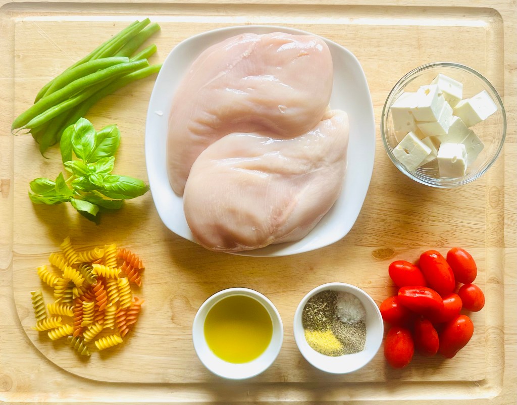 Ingredients used to make a roasted veggie pasta with chicken and feta