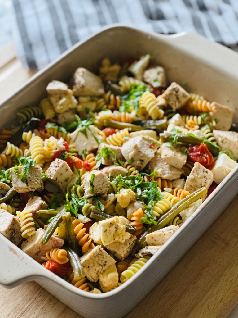 Baking dish with baked chicken, roasted veggies, and rotini