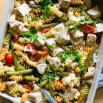 Baking dish with baked chicken, roasted veggies, and rotini