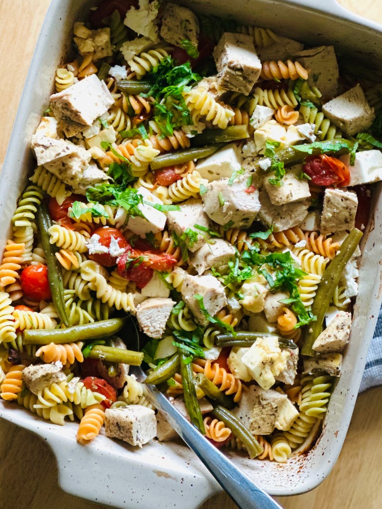 Baking dish with baked chicken, roasted veggies, and rotini