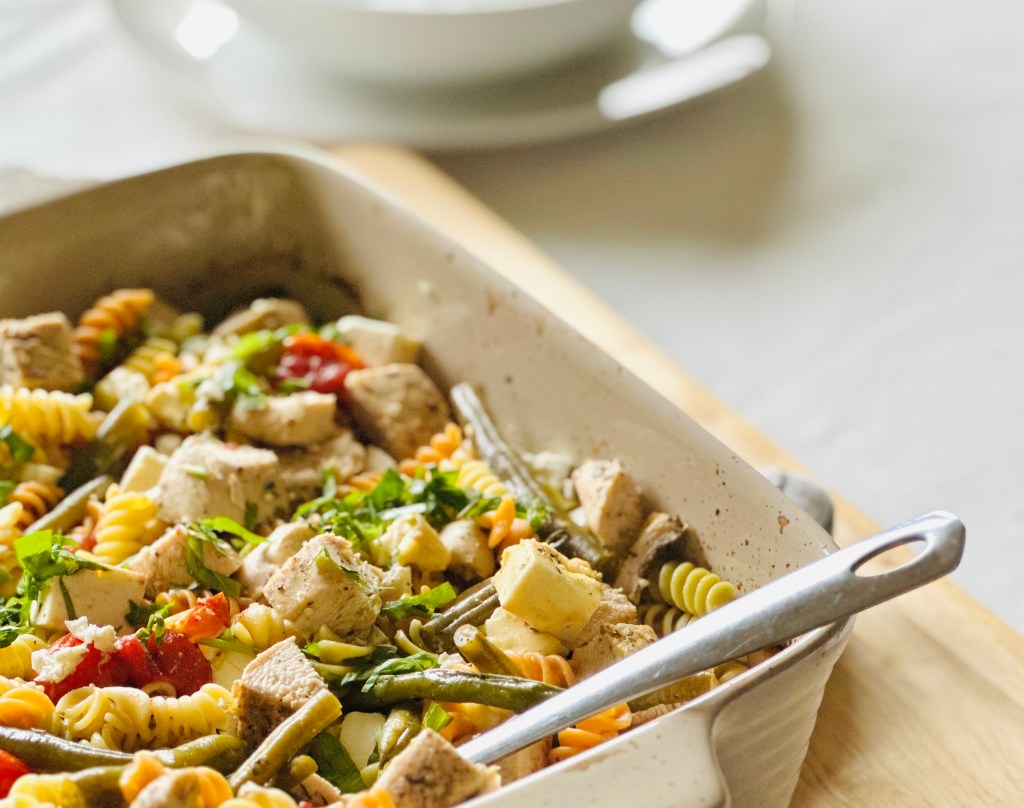 Baking dish with baked chicken, roasted veggies, and rotini
