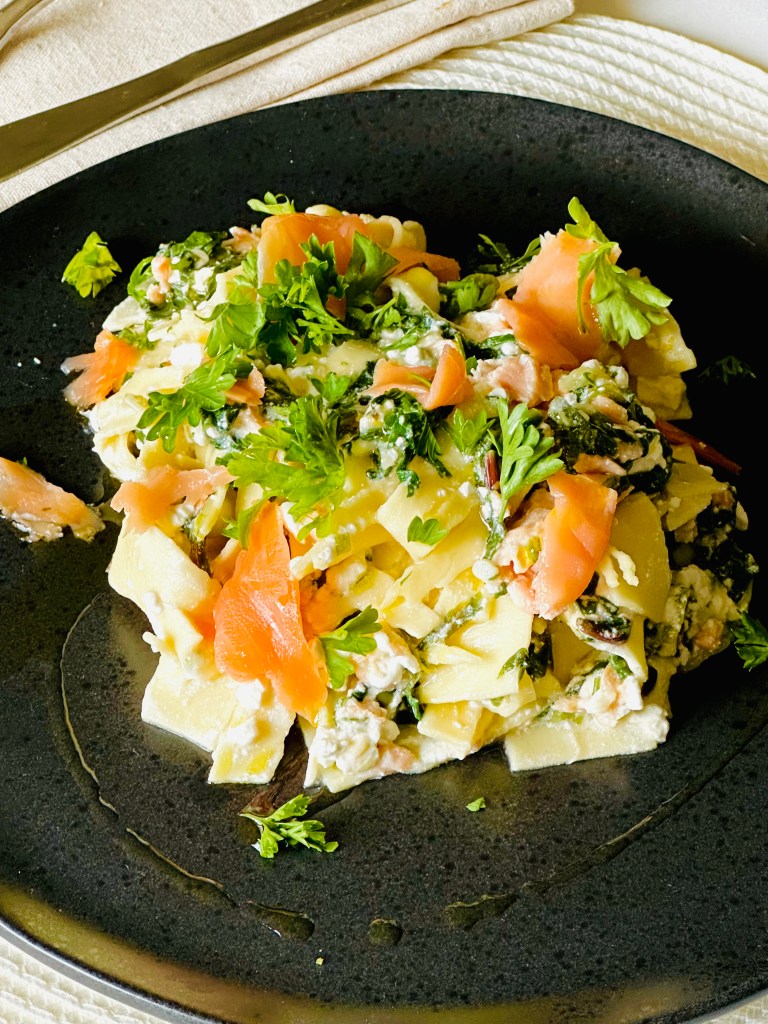 Smoked salmon layered with lasagna, cottage cheese, Parmesan cheese, lemon, and greens
