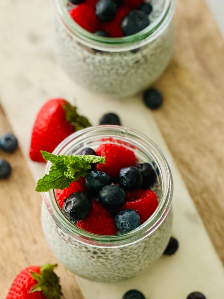 2 jars full of chia seed pudding and fresh berries