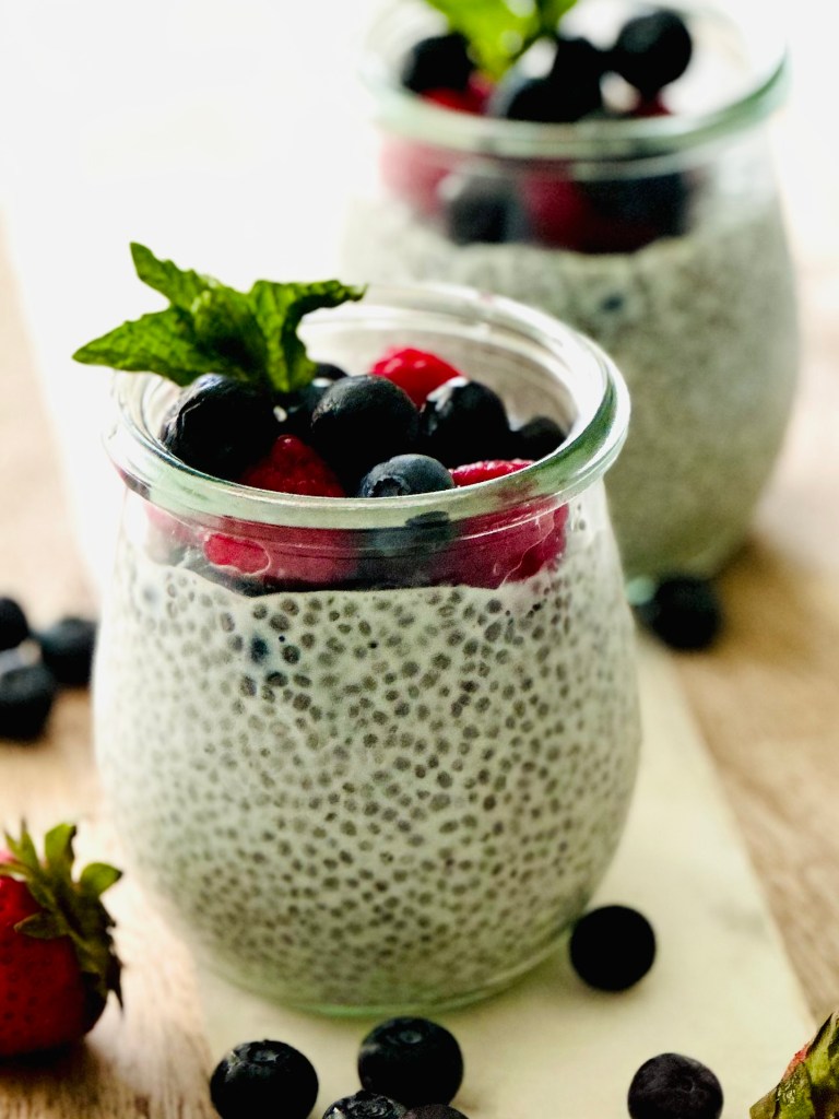 2 jars full of chia seed pudding and fresh berries