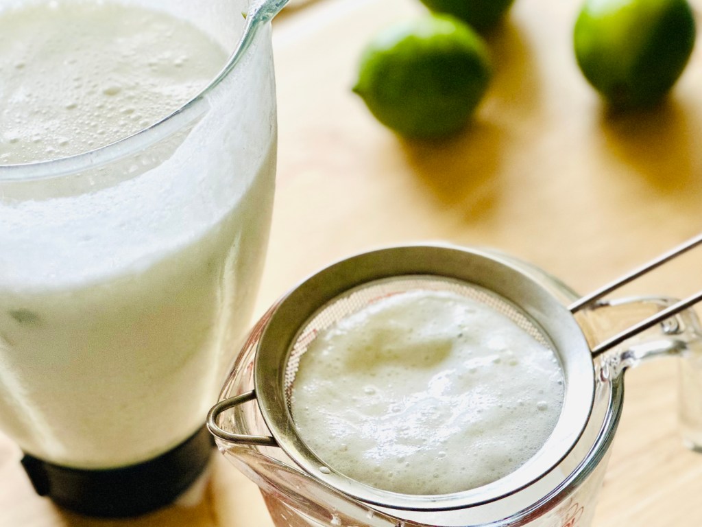 Brazilian lemonade being strained into a glass
