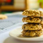 A plate with 4 oatmeal raisin cookies stacked on top of each other