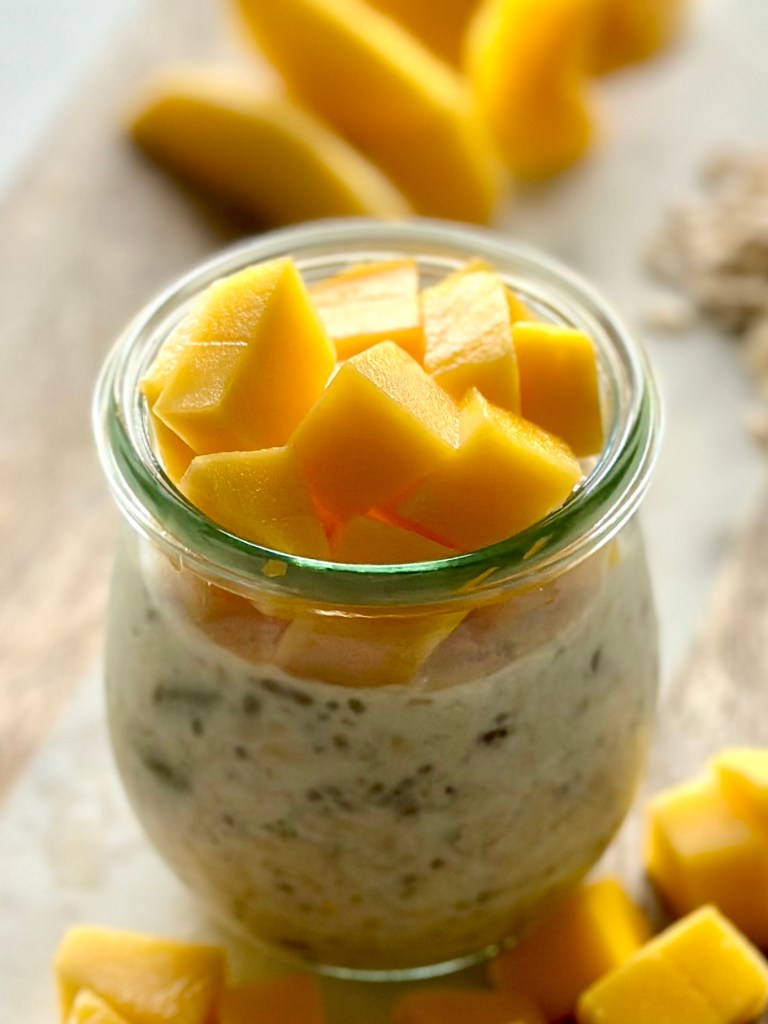 Jar filled with overnight oats and sliced mango