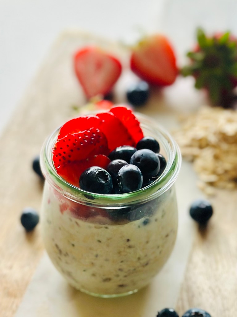 Jar filled with overnight oats and assorted berries