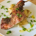 Serving plate of roasted rabbit and potatoes with parsley as garnish