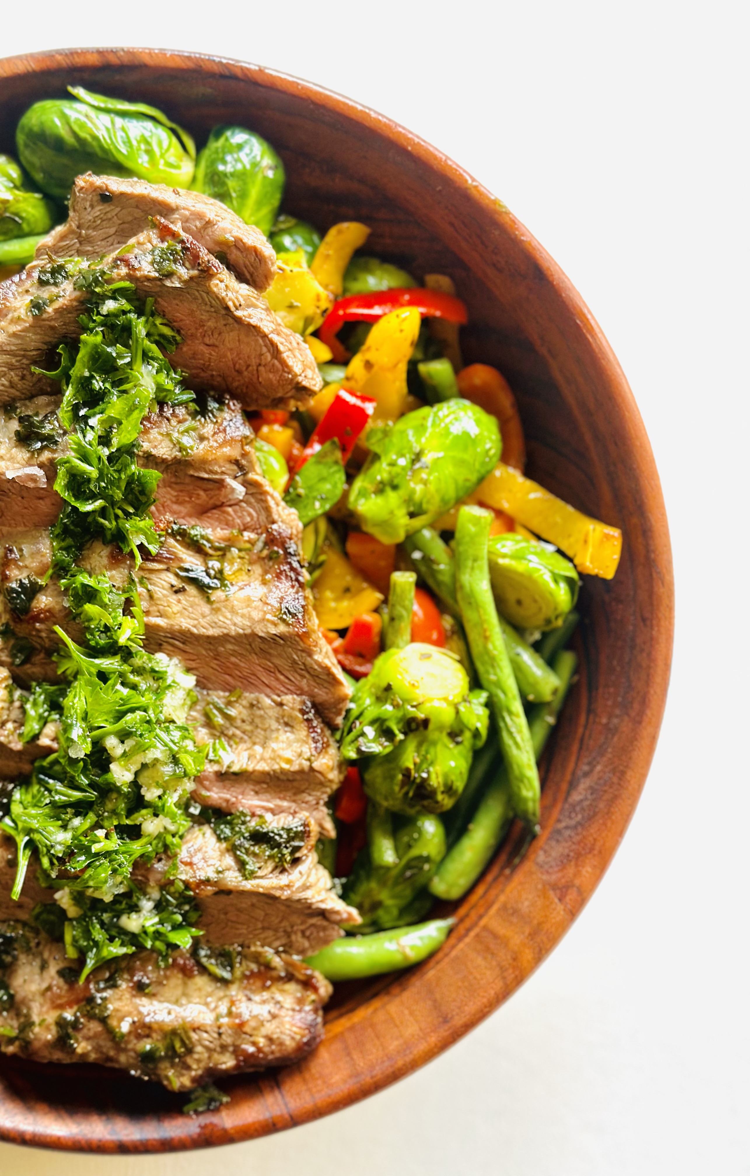 Serving bowl of pan-fried flat iron steak with vegetables