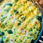 Baked spaghetti frittata with zucchini and peas in a frying pan
