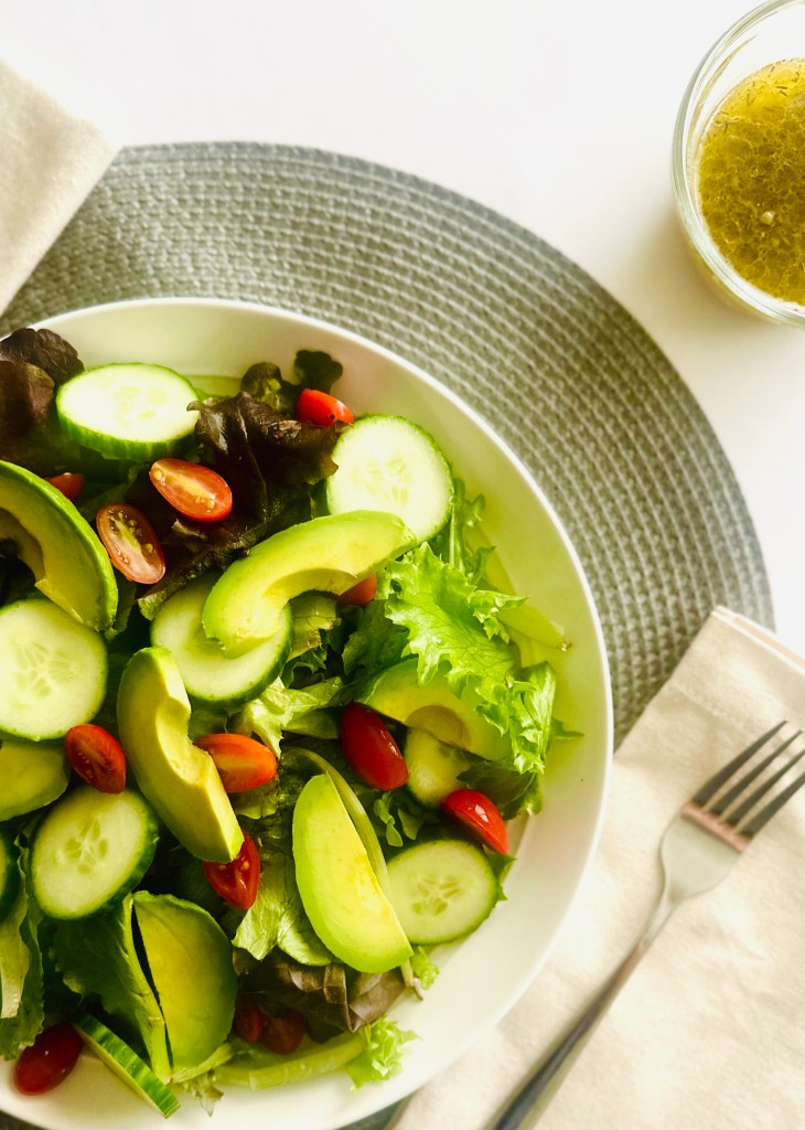 Simple green salad with cucumber, tomatoes, and avocado slices