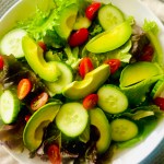 Simple green salad with cucumber, tomatoes, and avocado slices