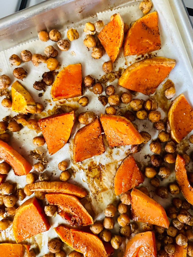 A covered sheet pan with roasted butternut squash and chickpeas
