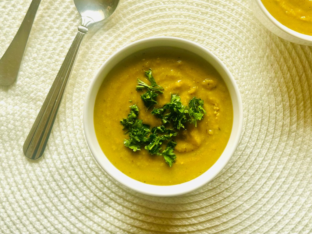 A bowl of homemade vegetarian split pea soup with parsley as garnish