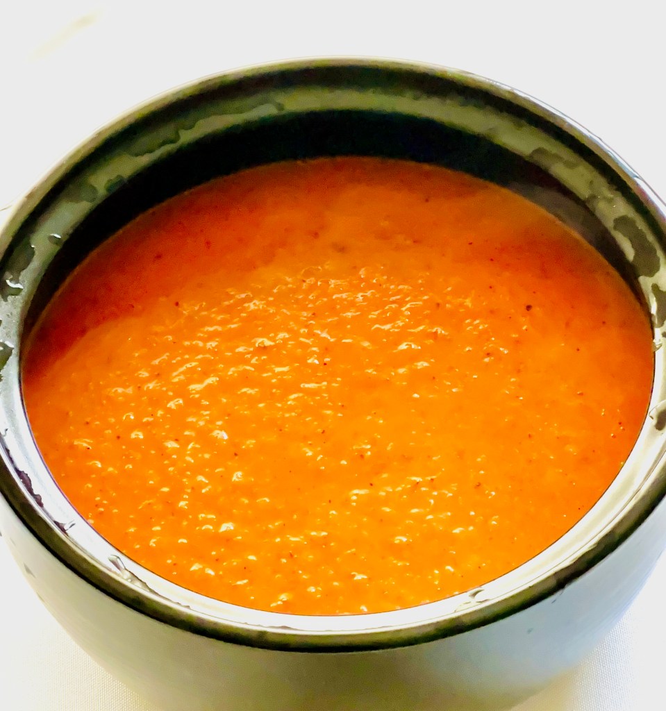 A soup pot full of creamy tomato basil soup