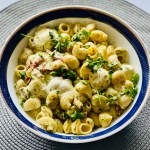 A serving bowl of homemade creamy pesto pasta with mozzarella