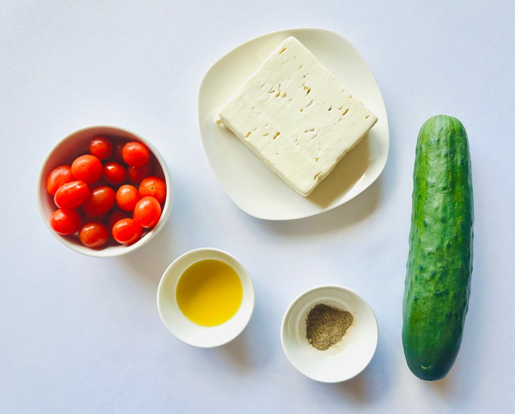 A photo of ingredients used to make cucumber, tomato, and feta skewers