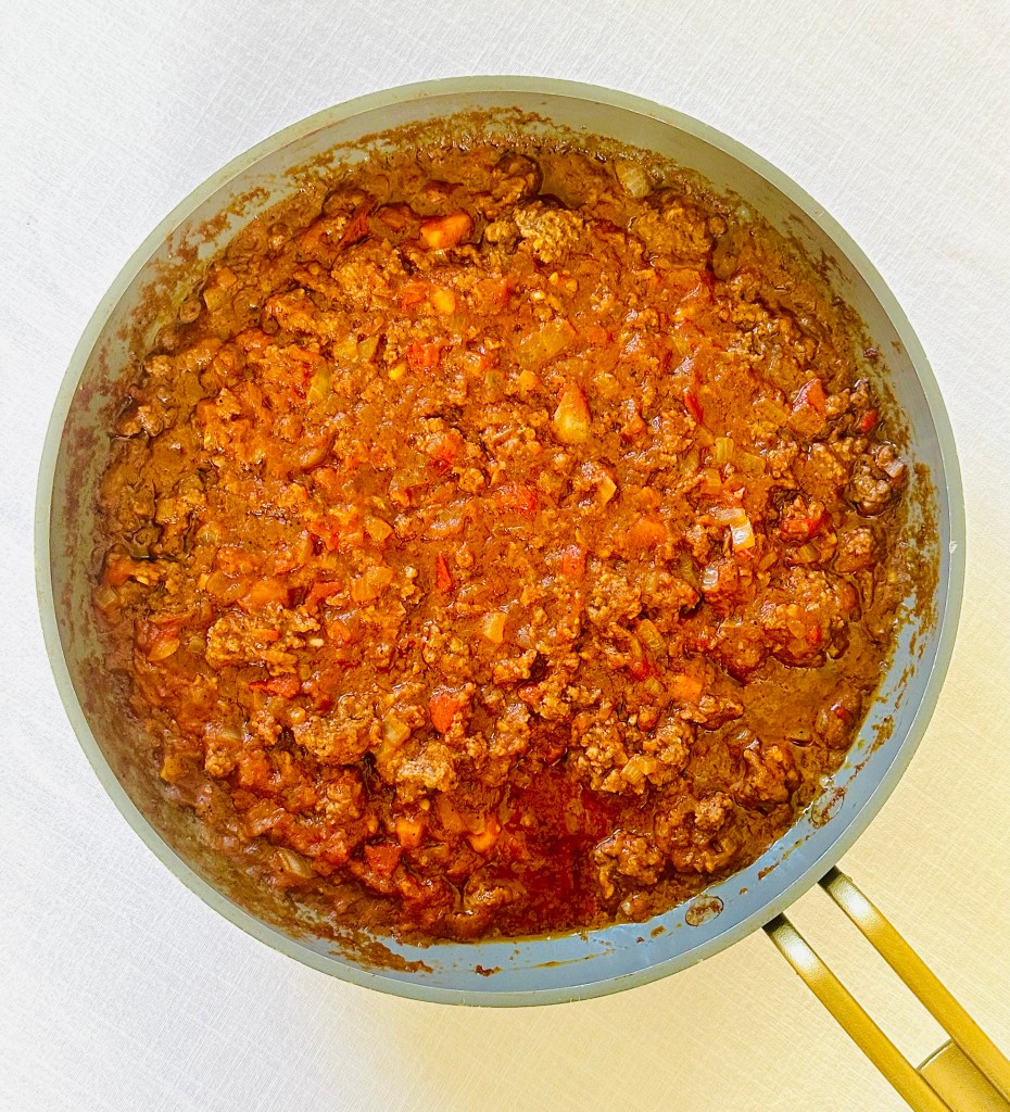 Ground beef cooked in a pan with garlic, onion, and spices