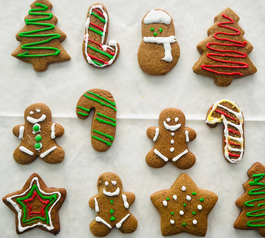 A baking sheet filled with gingerbread cookies decorated with icing
