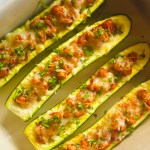 Homemade zucchini boats with chickpeas and tomatoes in a baking dish
