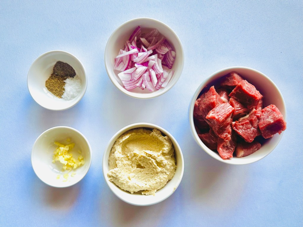 A photo of ingredients used to make homemade hummus and steak plate