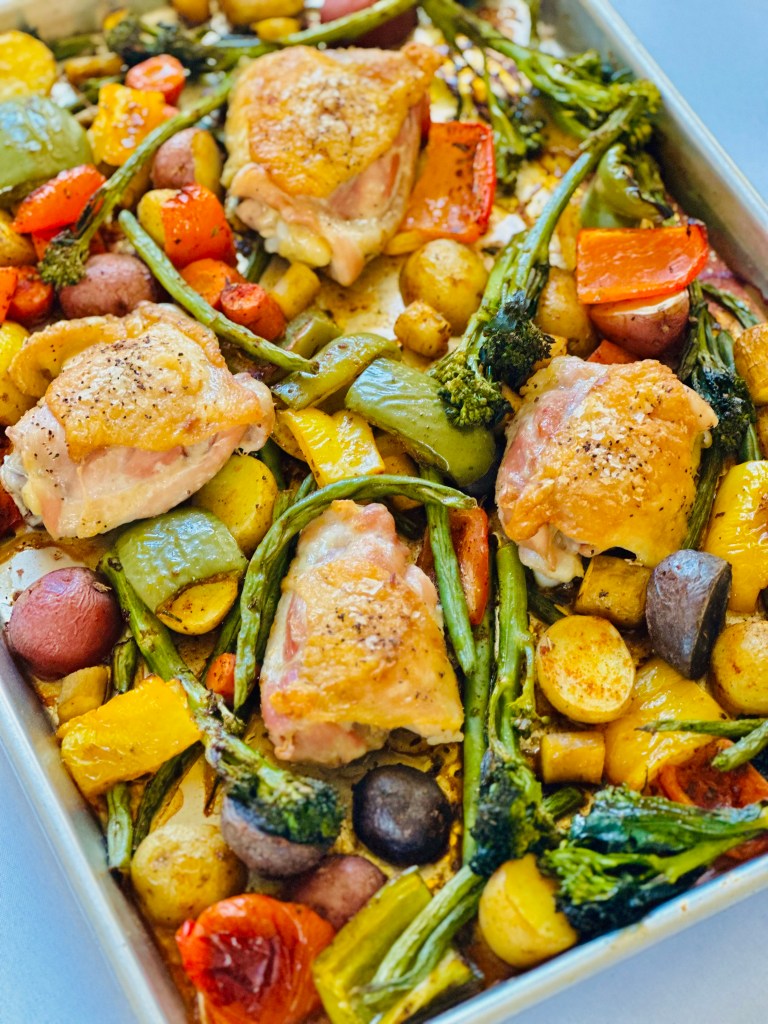 Juicy crisp chicken and roasted rainbow vegetables nestled in a sheet pan