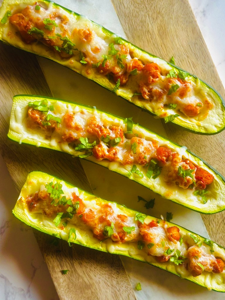 Homemade zucchini boats with chickpeas and tomatoes assembled on a cutting board