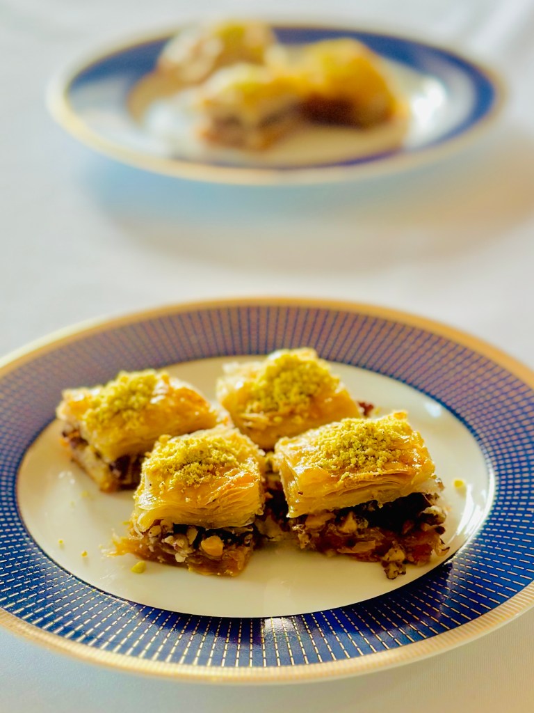A photo of classic baklava drizzled with simple syrup and topped with crushed pistachios