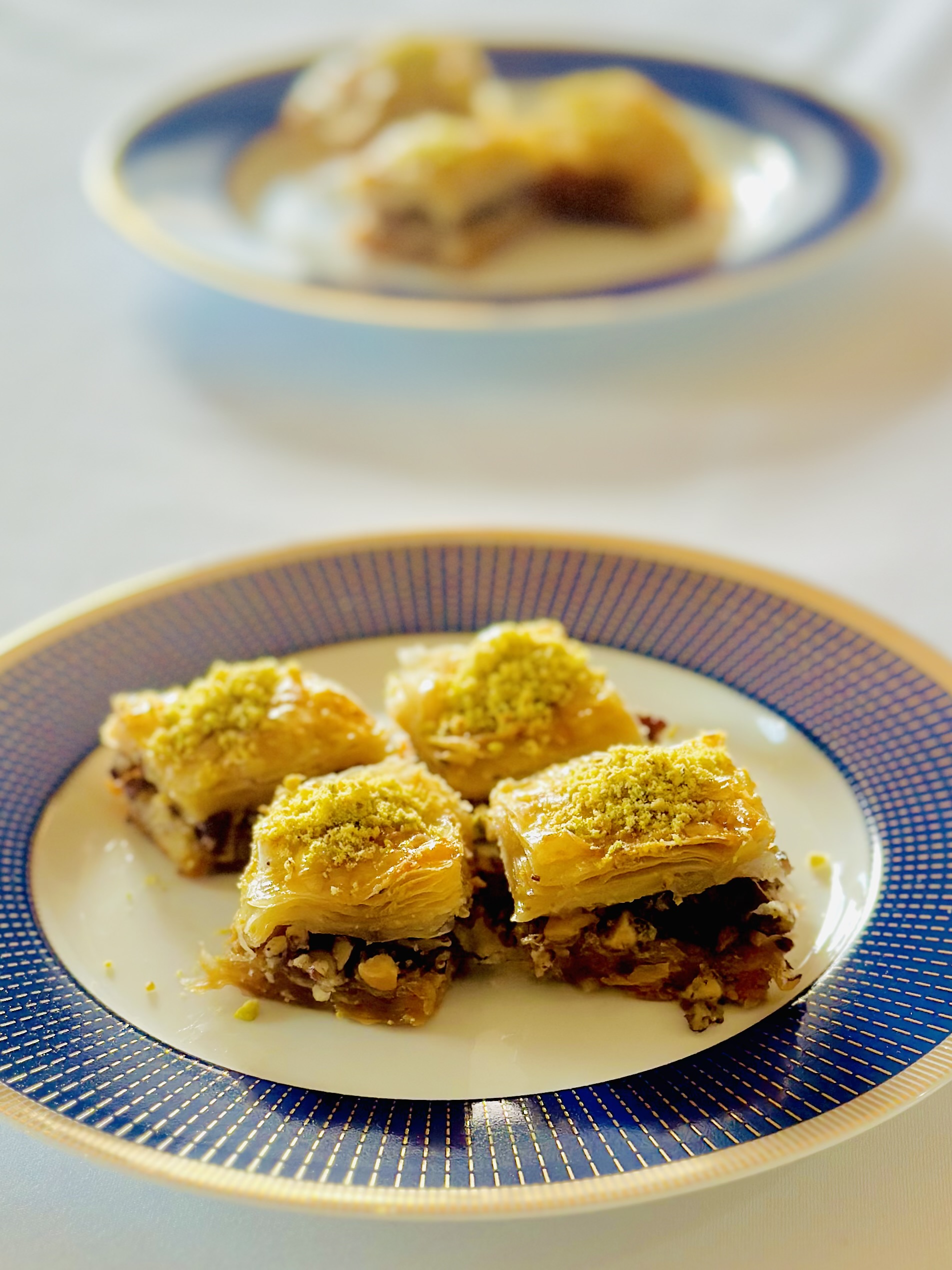A photo of classic baklava drizzled with simple syrup and topped with crushed pistachios