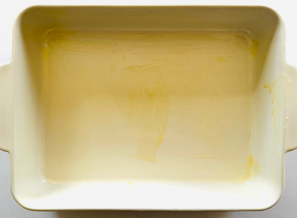The interior of a baking pan spread with melted butter