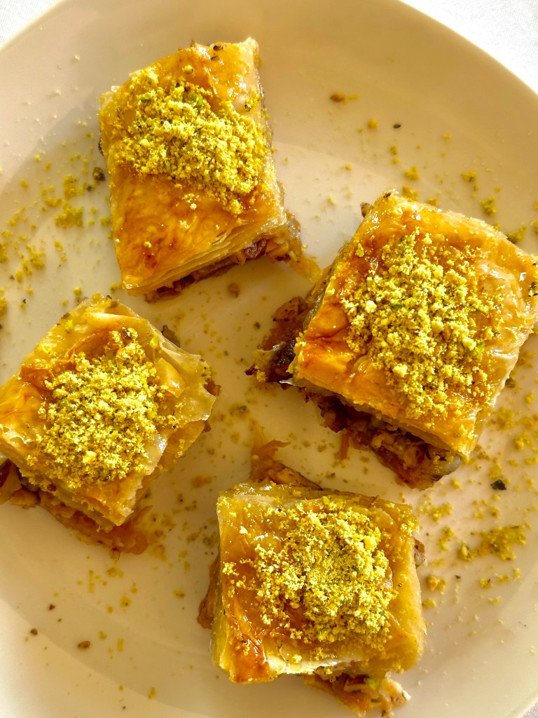 A photo of classic baklava drizzled with simple syrup and topped with crushed pistachios