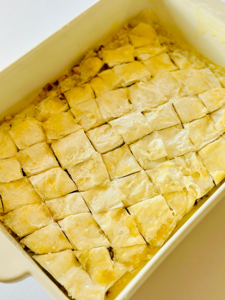 A baking pan full of baklava wrapped in phyllo dough and cut into diamond shapes