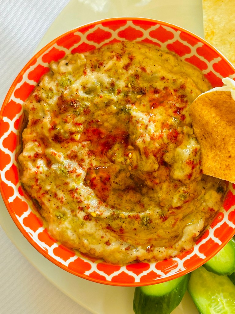 A plate of homemade baba ganoush garnished with parsley and paprika