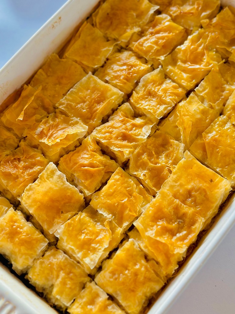 A baking dish full of savory baklava prepared with ground beef and onion filling