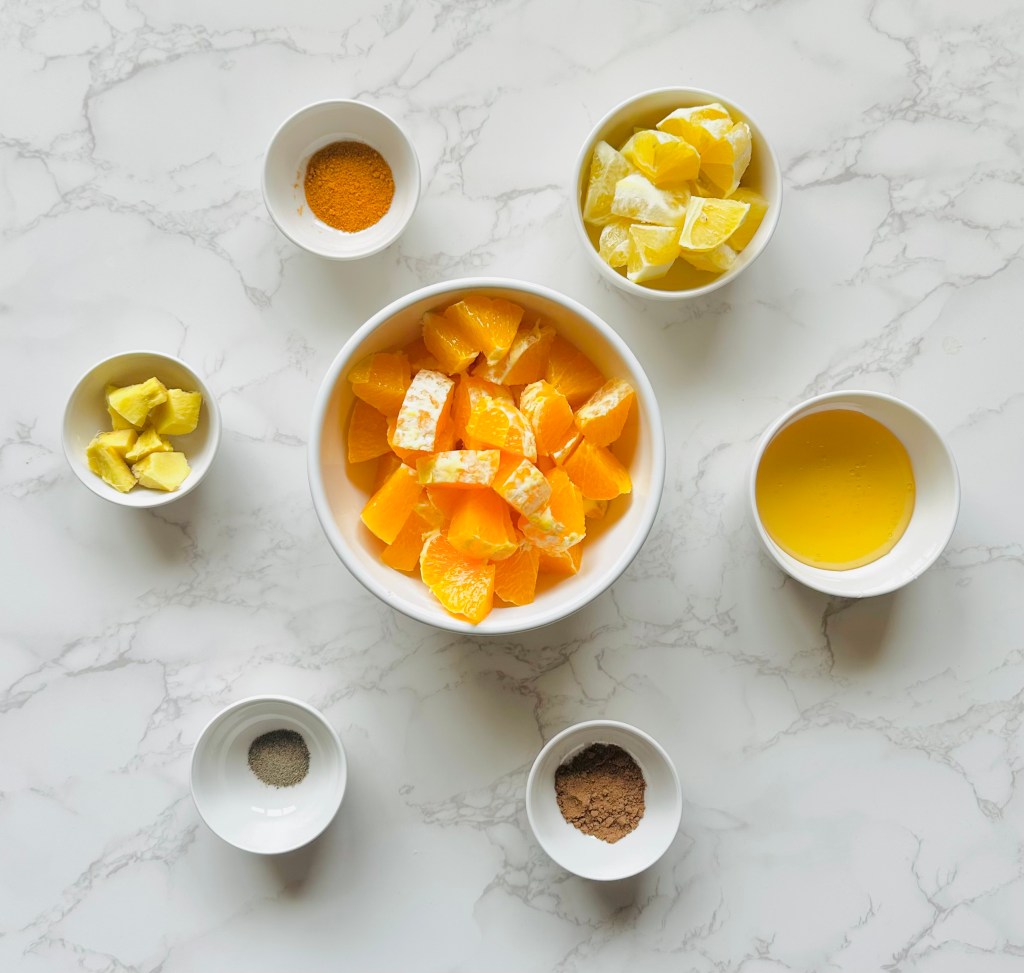 A photo of ingredients used to make cold relief tea with lemon, orange, and ginger
