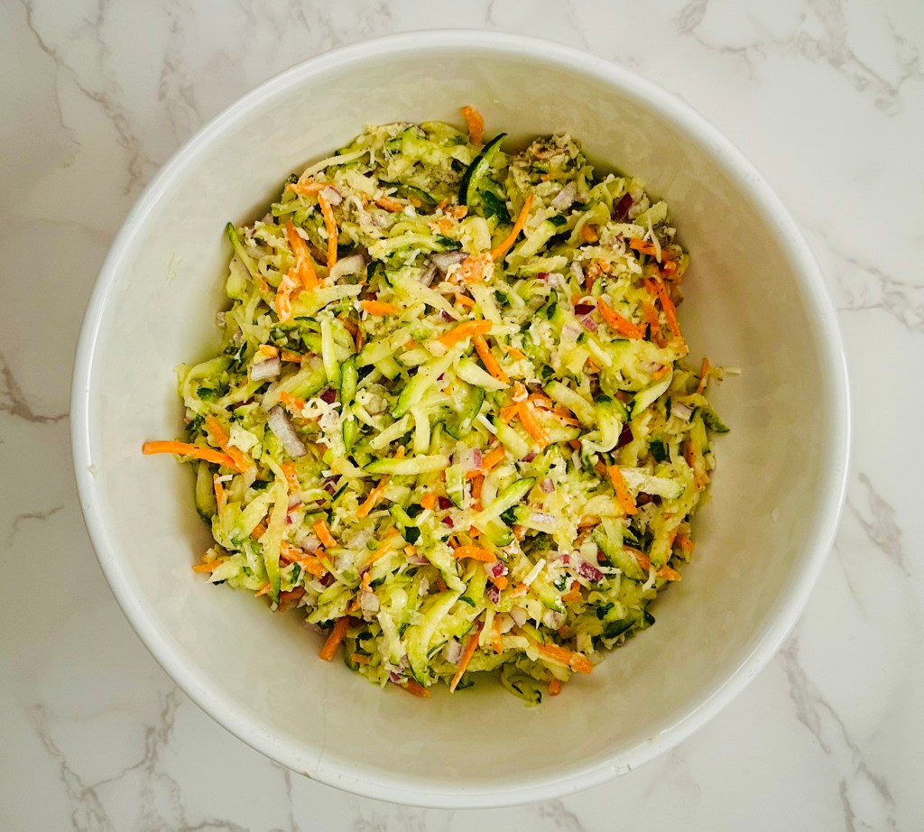 A bowl of batter used to make zucchini fritters