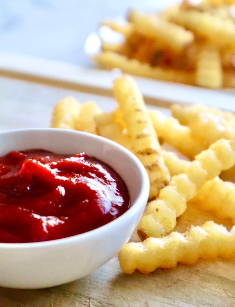 A bowl of homemade ketchup served alongside crinkle-cut fries